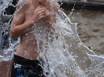 Boy splashing in water to stay cool